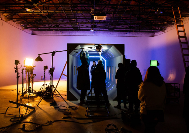 A photo of a dimly lit production studio with the team at work